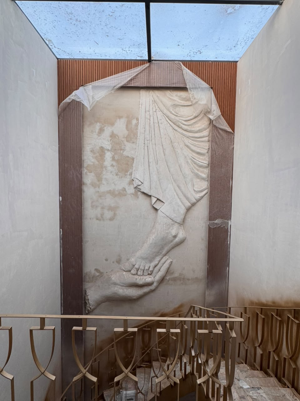 Bas-relief sculpture in the double-height atrium beneath a skylight at our Sector 41F Noida kothi