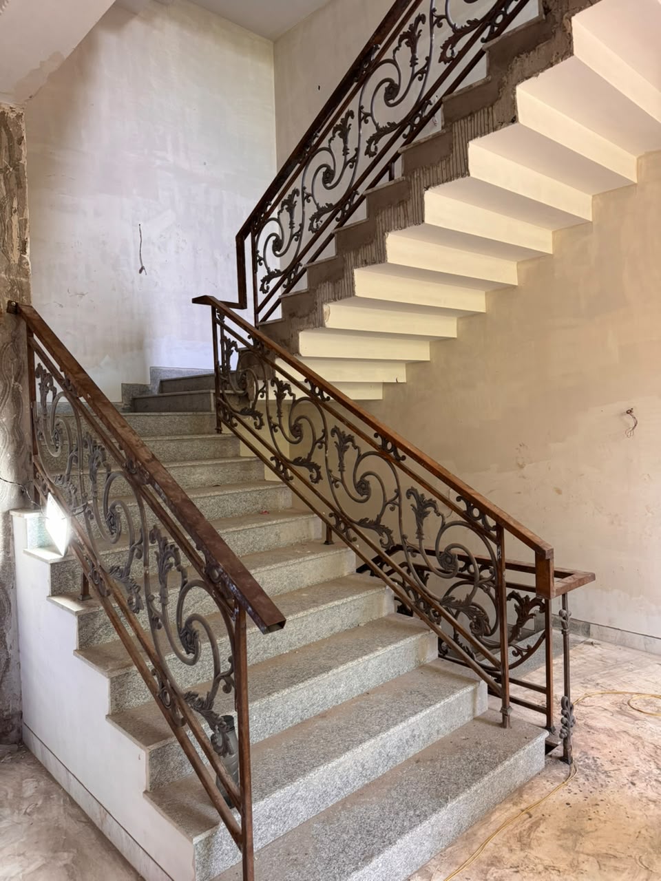 Granite stair treads with ornate wrought-iron railing at our Sector 41F Noida kothi
